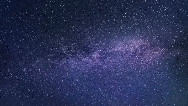 Stars visible in the night sky over a dark horizon
